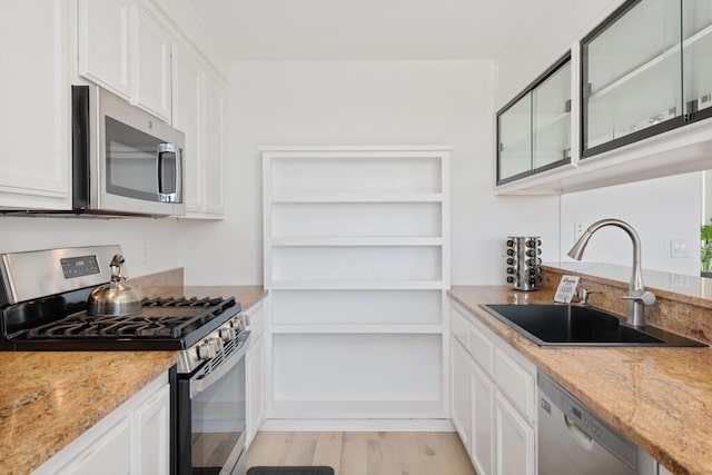 kitchen featuring white cabinetry, sink, light wood-type flooring, and stainless steel appliances