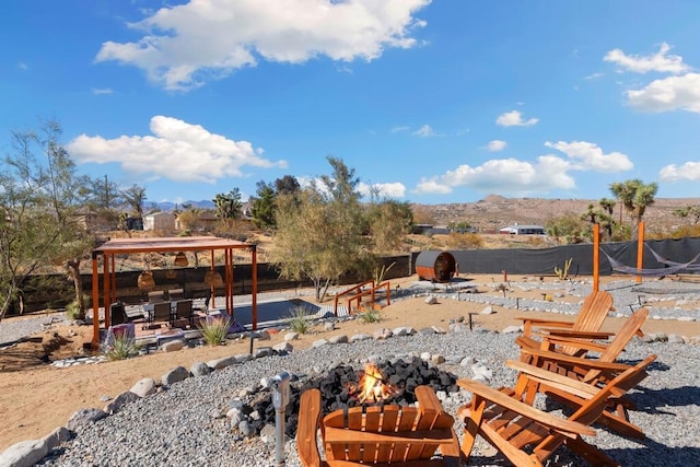 view of yard with a mountain view, a gazebo, and an outdoor fire pit