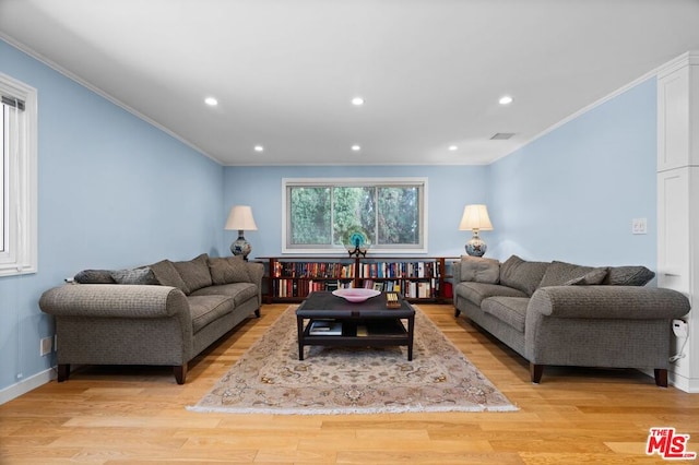 living room with light wood-type flooring and crown molding