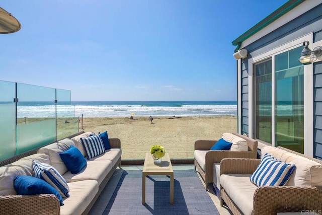 view of patio with a beach view, outdoor lounge area, and a water view