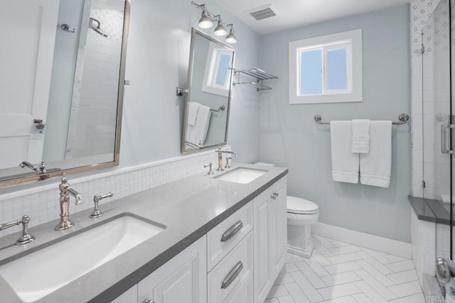 bathroom with a sink, visible vents, baseboards, and toilet