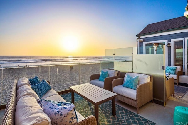 view of patio / terrace with a beach view, a balcony, and a water view