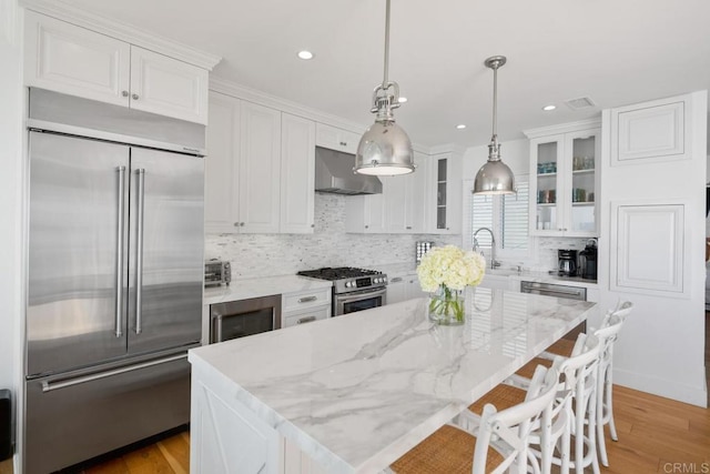 kitchen with white cabinetry, ventilation hood, stainless steel appliances, and glass insert cabinets