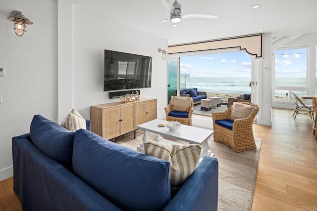 living area with recessed lighting, light wood-type flooring, and a ceiling fan