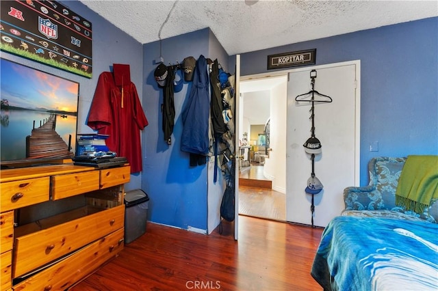 bedroom with dark hardwood / wood-style floors and a textured ceiling