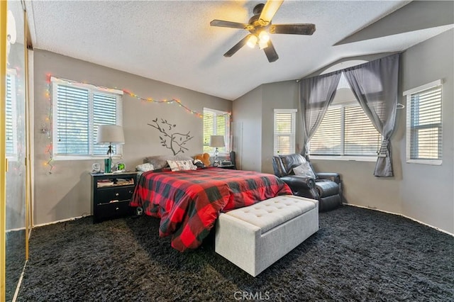 carpeted bedroom featuring ceiling fan, a textured ceiling, and vaulted ceiling