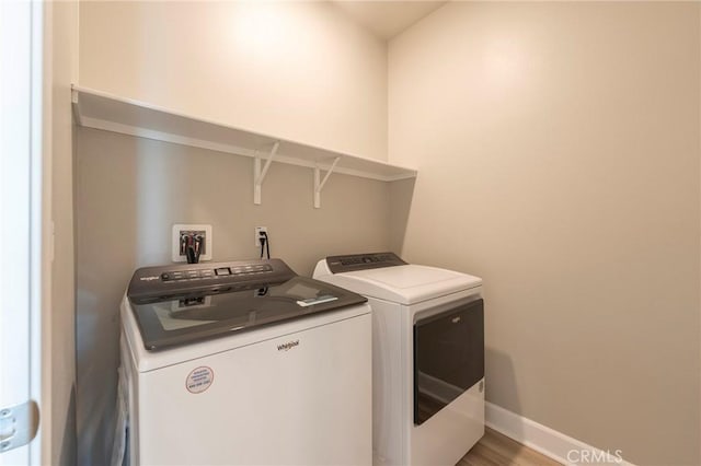 laundry area featuring wood-type flooring and independent washer and dryer