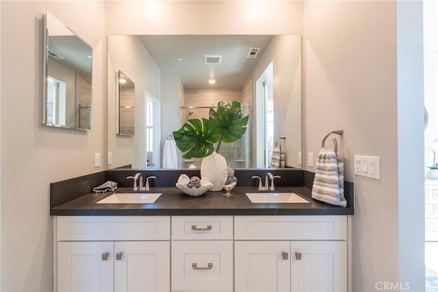 bathroom with vanity and a shower with door