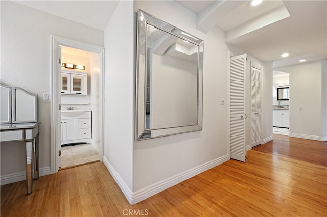 hall featuring sink and light wood-type flooring