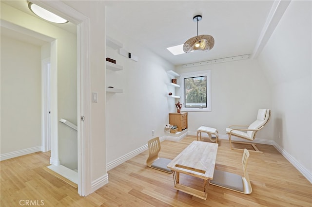 living area with a skylight and light wood-type flooring