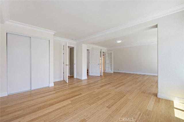 unfurnished bedroom with light hardwood / wood-style floors, a closet, and ornamental molding