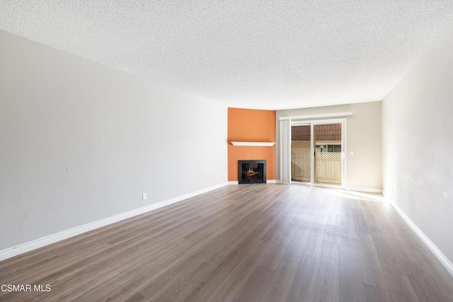 unfurnished living room with hardwood / wood-style floors and a textured ceiling