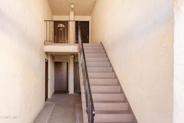 stairs with concrete flooring