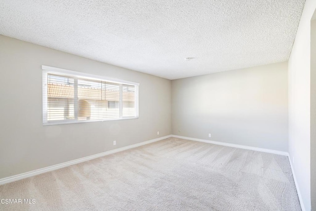 carpeted empty room featuring a textured ceiling