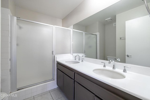 bathroom featuring tile patterned floors, toilet, an enclosed shower, and vanity