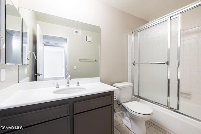 full bathroom featuring tile patterned flooring, vanity, toilet, and combined bath / shower with glass door