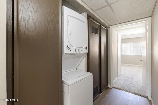 laundry area featuring light hardwood / wood-style flooring and stacked washer and clothes dryer