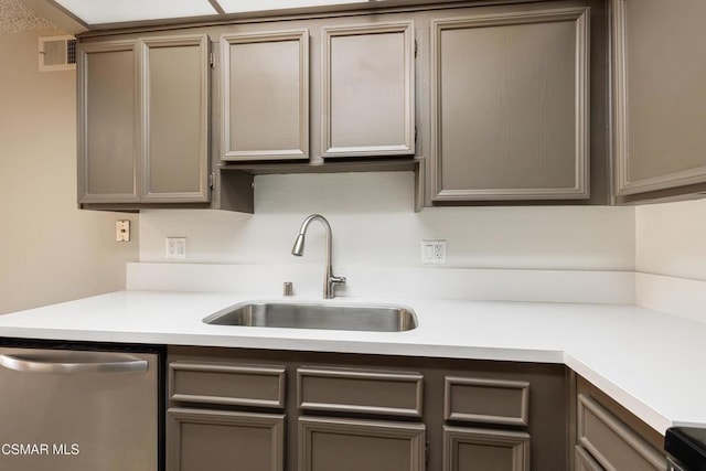 kitchen featuring dishwasher, gray cabinets, and sink