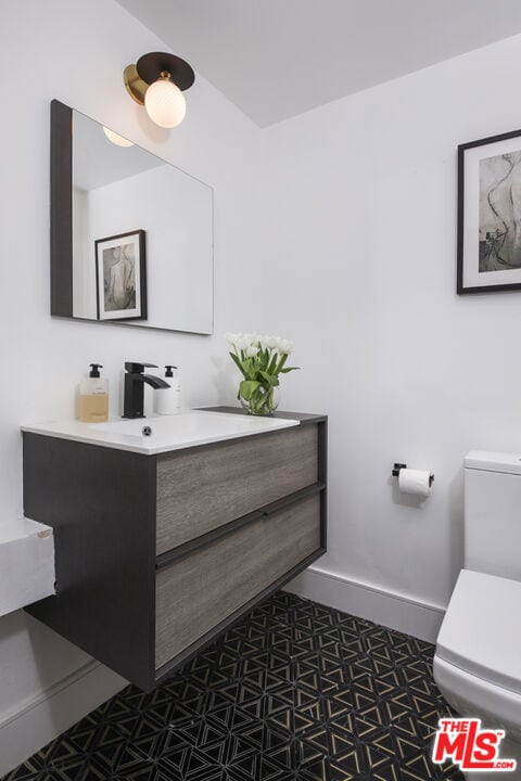 bathroom featuring tile patterned flooring, vanity, and toilet