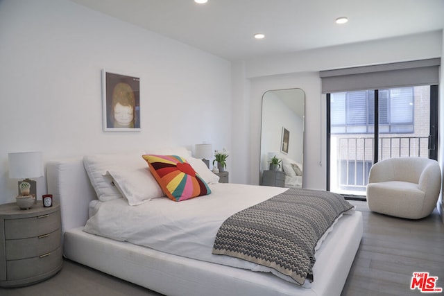 bedroom with hardwood / wood-style floors and multiple windows