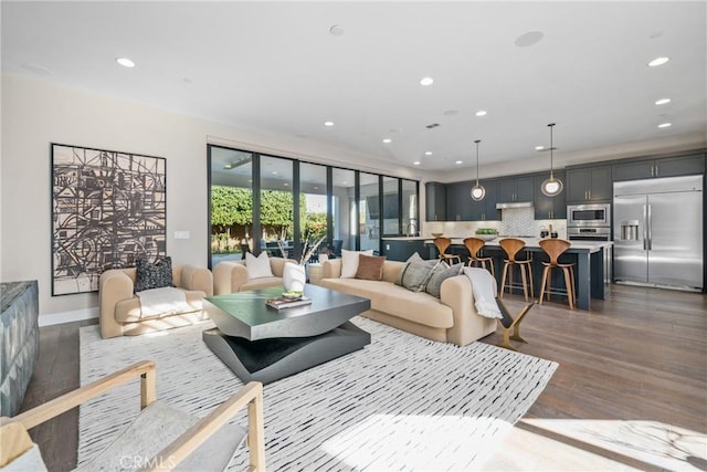 living area with recessed lighting, baseboards, and wood finished floors