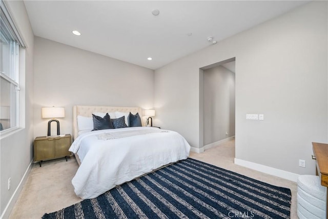 bedroom with baseboards, recessed lighting, and light colored carpet