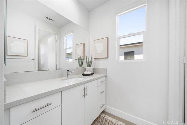 bathroom featuring baseboards, visible vents, and vanity