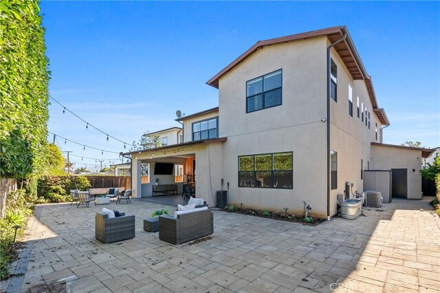 back of house featuring a patio area, an outdoor living space, and central AC