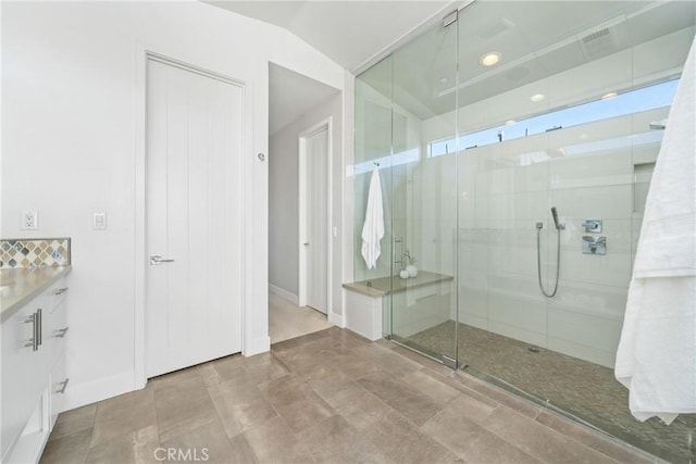 full bathroom featuring visible vents, baseboards, lofted ceiling, vanity, and a shower stall