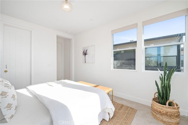 bedroom featuring light carpet and baseboards