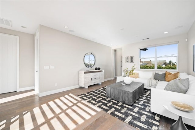 living area with recessed lighting, visible vents, and wood finished floors