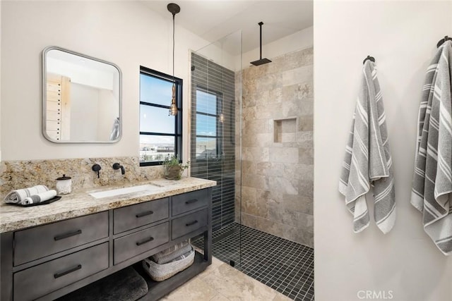 bathroom featuring tile patterned flooring, vanity, and tiled shower