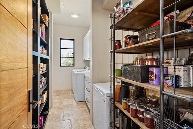 clothes washing area featuring cabinets and separate washer and dryer