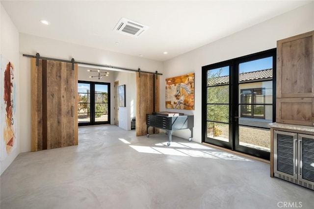 interior space with french doors, a barn door, and heating unit