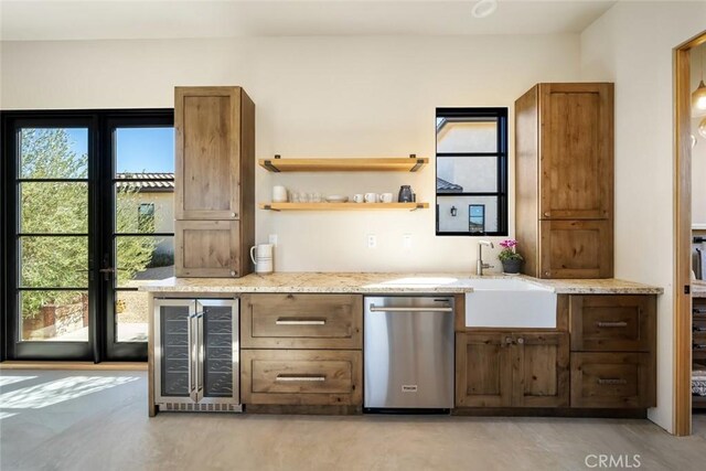 bar with dishwasher, light stone counters, sink, and beverage cooler