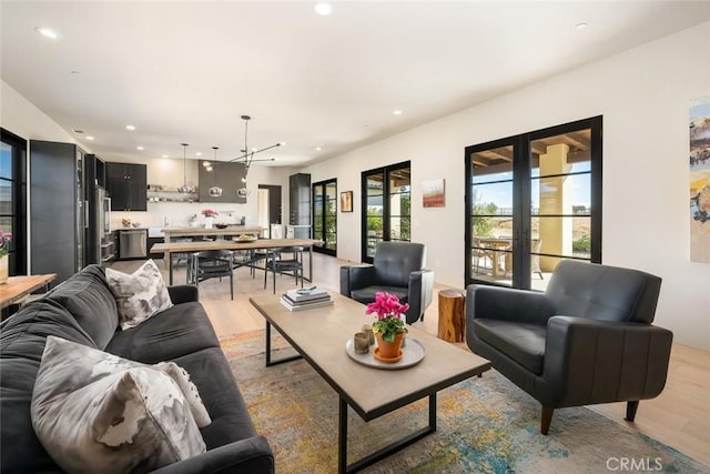 living room with an inviting chandelier and light wood-type flooring