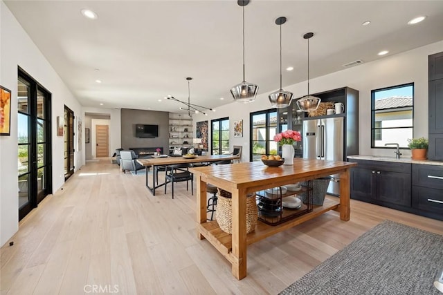 kitchen featuring light hardwood / wood-style flooring, a wealth of natural light, and high quality fridge