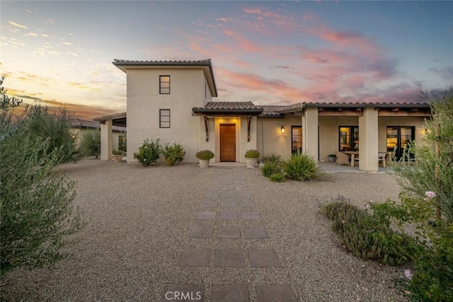 back house at dusk with a patio