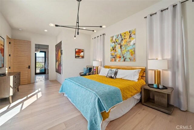 bedroom featuring light hardwood / wood-style floors and an inviting chandelier