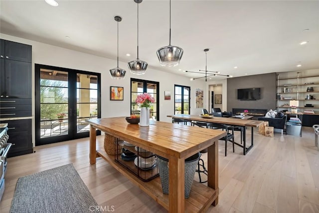 dining area with light hardwood / wood-style flooring, a wealth of natural light, and french doors