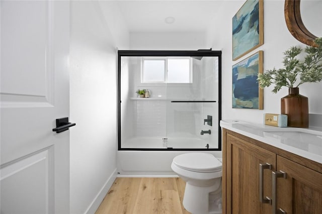 full bathroom with toilet, vanity, combined bath / shower with glass door, and hardwood / wood-style flooring