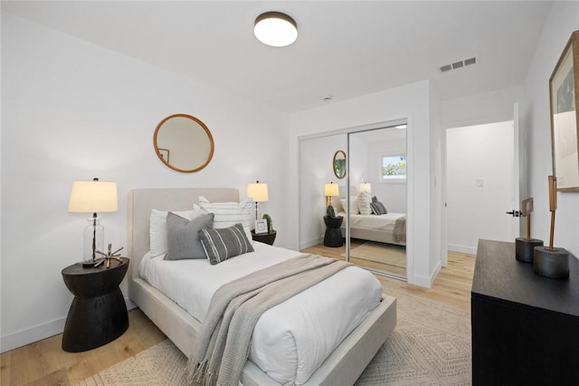 bedroom with light wood-type flooring and a closet