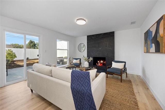 living room featuring a high end fireplace and light hardwood / wood-style floors