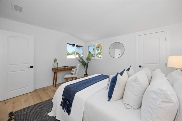 bedroom with hardwood / wood-style flooring and lofted ceiling