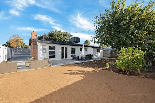 rear view of house with a patio and central AC