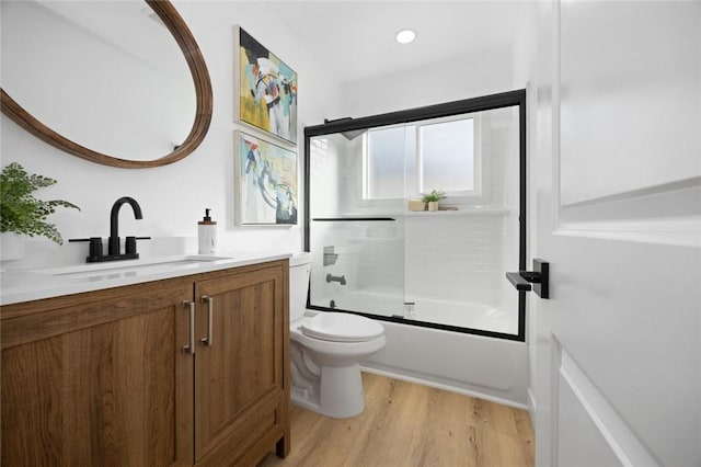 full bathroom featuring wood-type flooring, vanity, toilet, and enclosed tub / shower combo