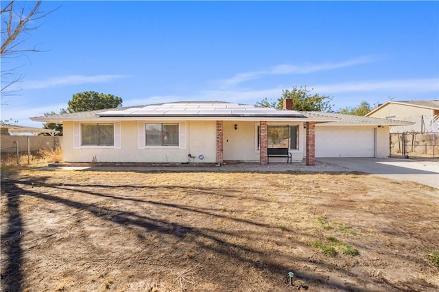 ranch-style home with solar panels and a garage