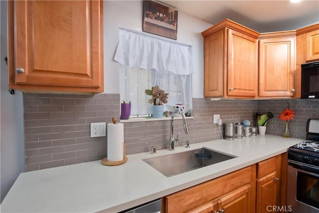 kitchen with black appliances, decorative backsplash, and sink