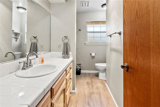 bathroom with vanity, wood-type flooring, and toilet