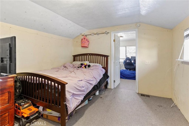 bedroom with light colored carpet and vaulted ceiling